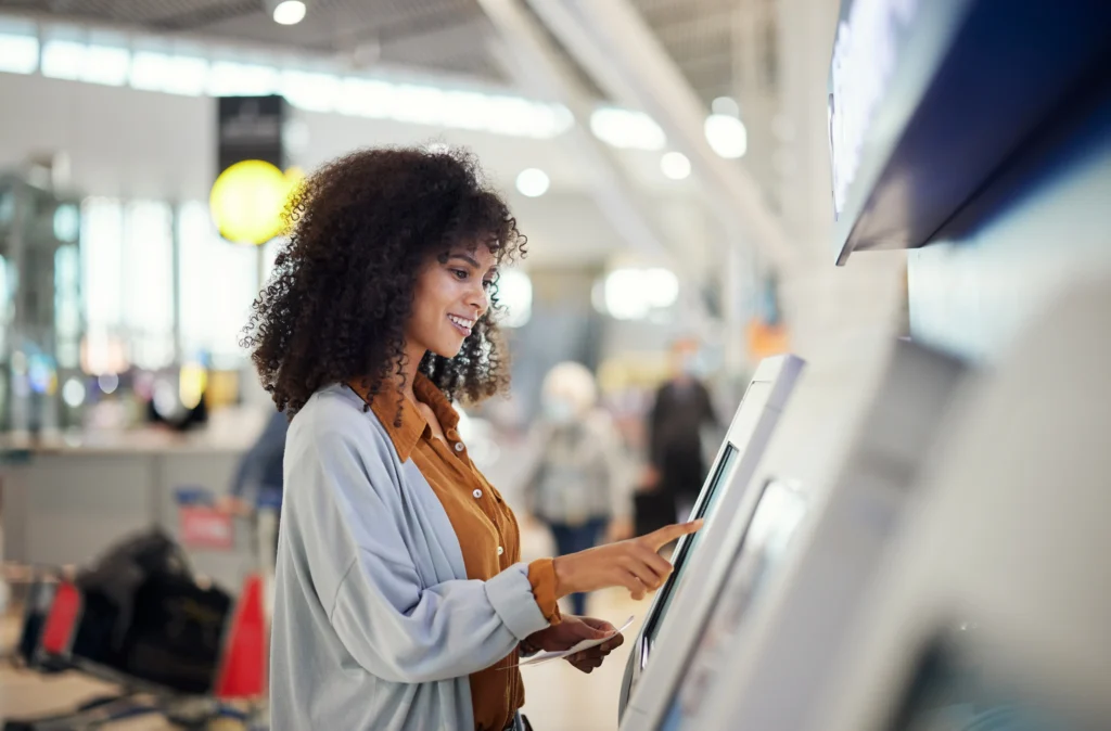 Woman smiling while using self-service kiosk at the airport