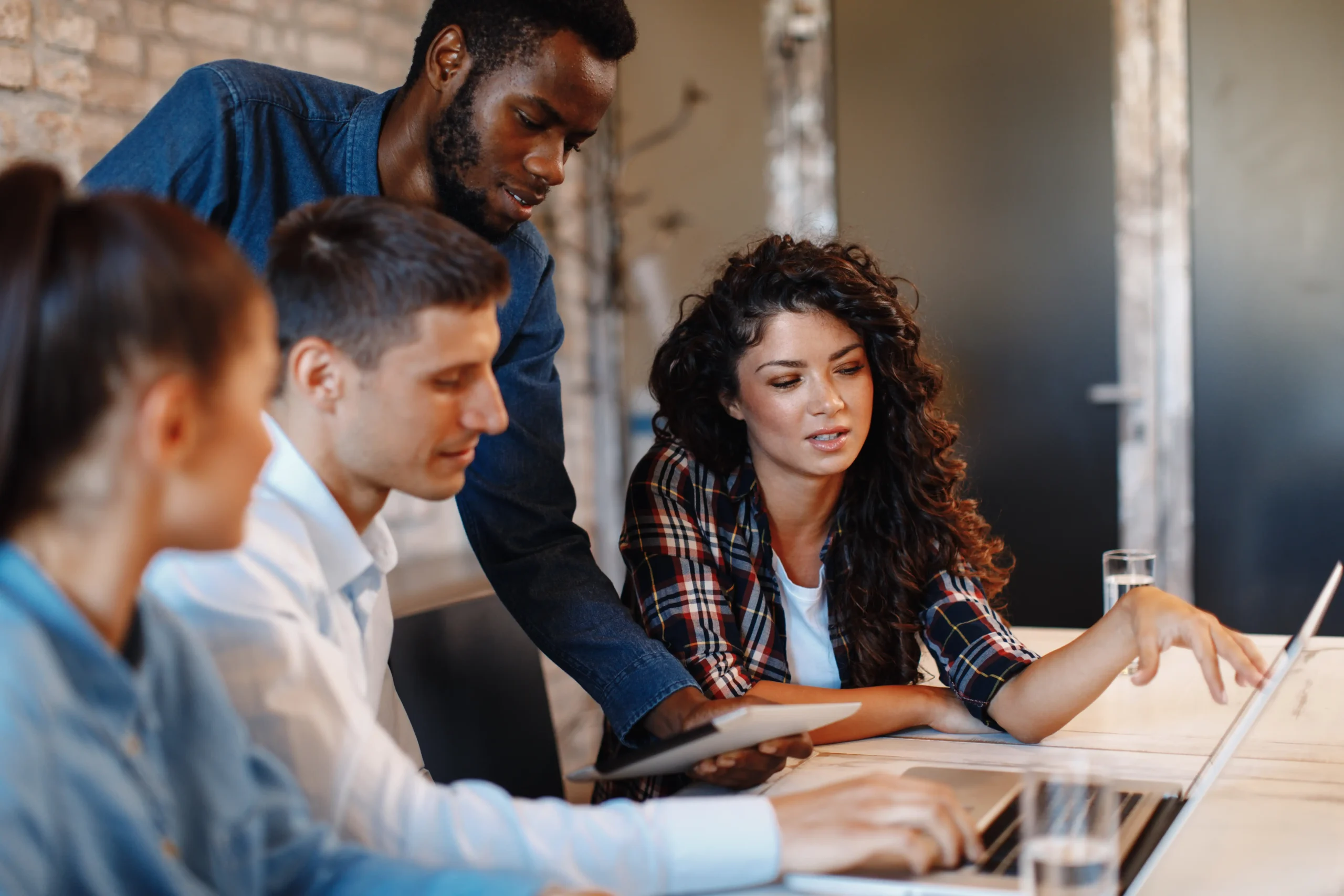 Coworkers gathered at desk sharing knowledge