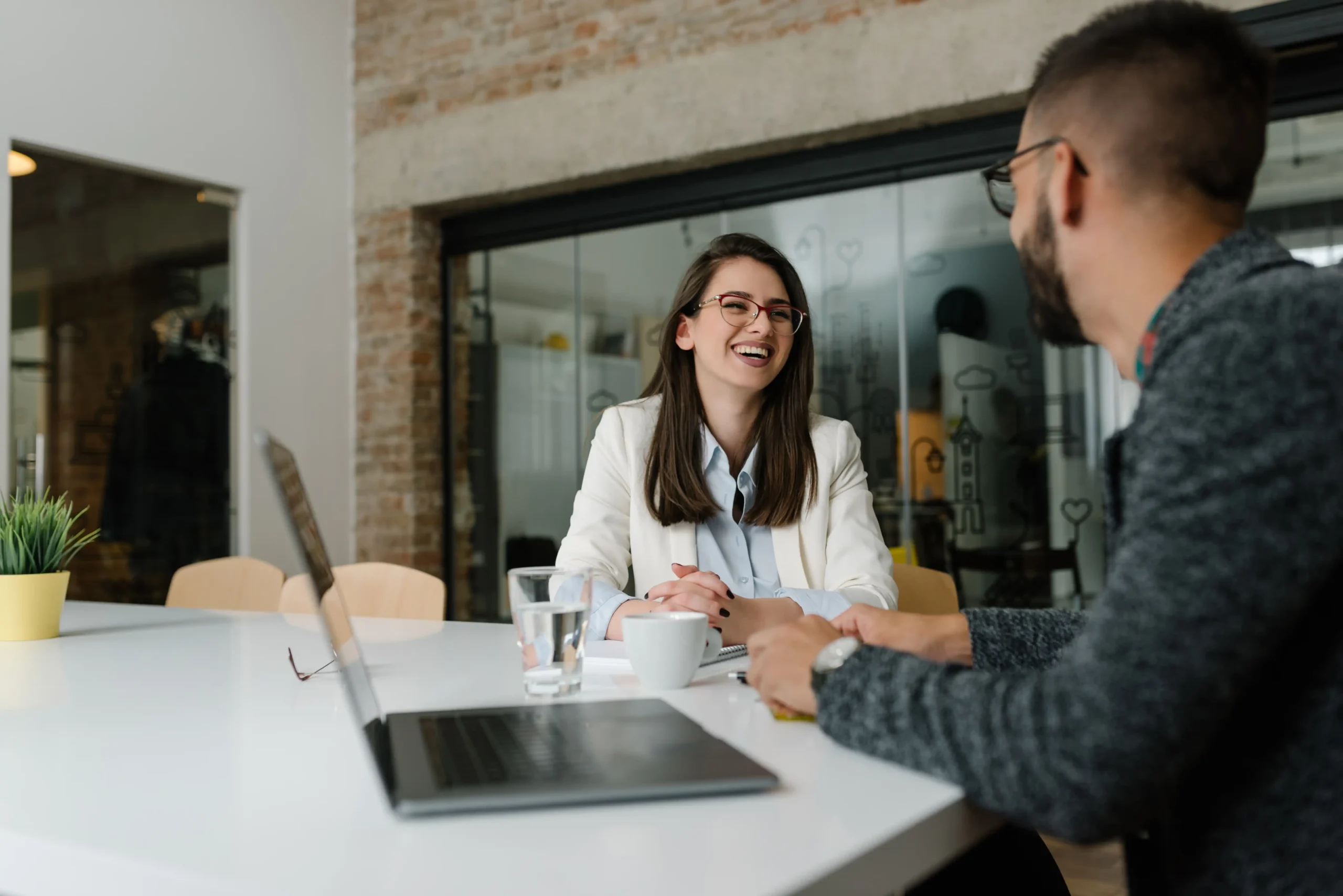 HR representative and coworker laughing at a conference table