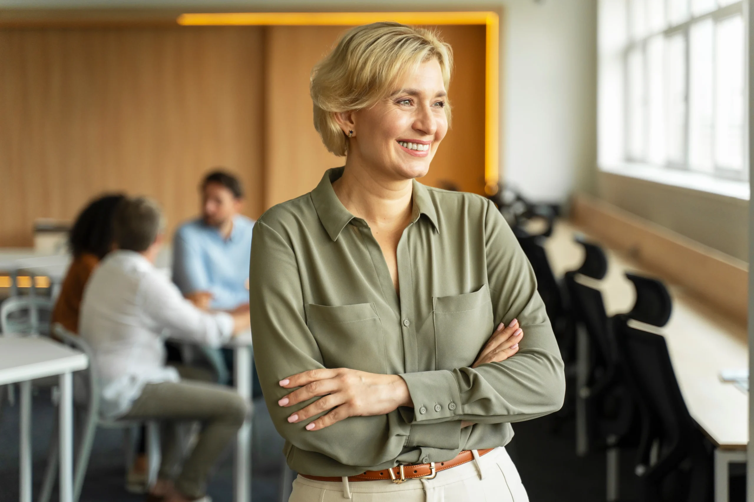 Business woman smiling and staring out of an office window