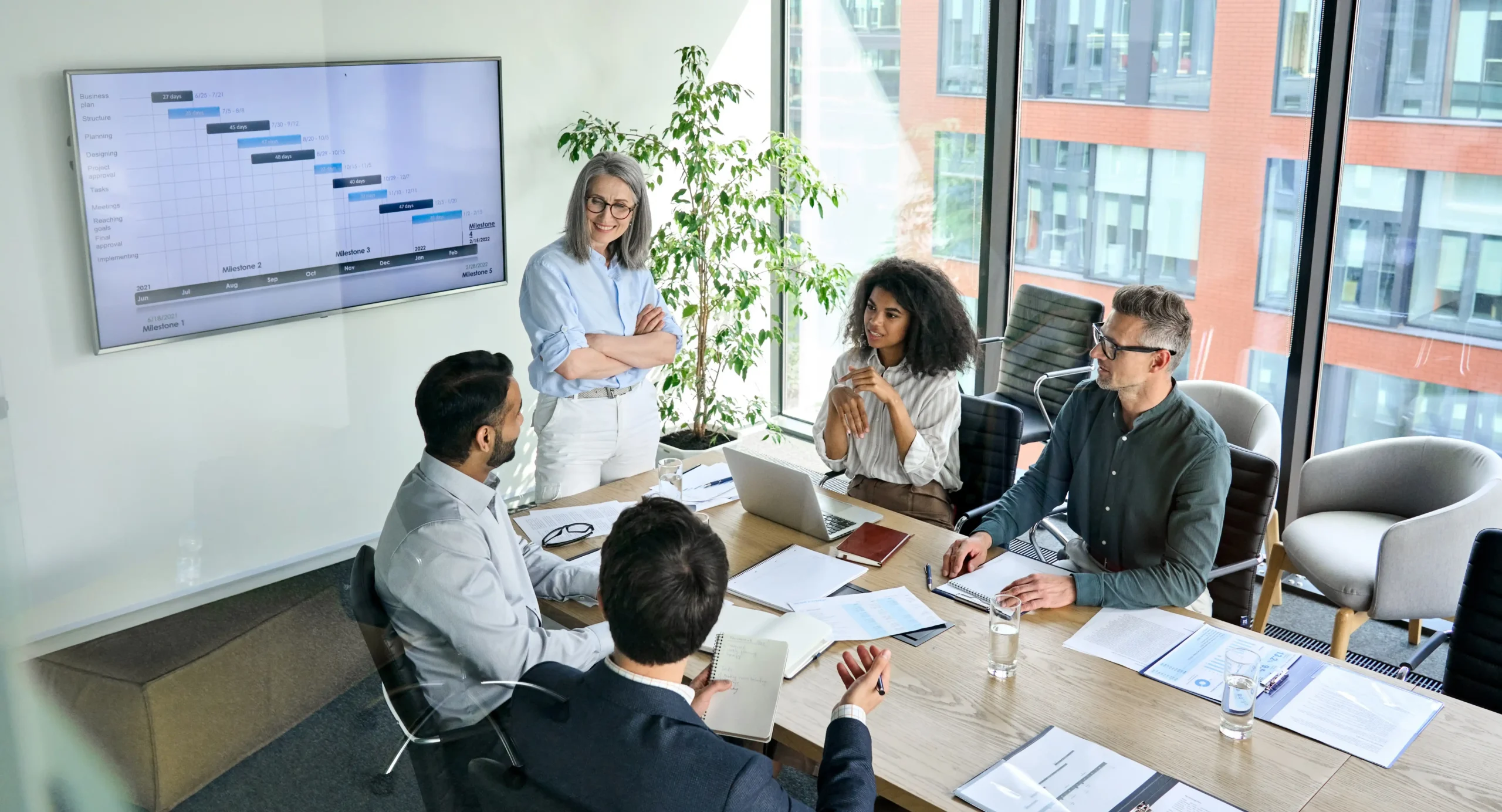 Coworkers strategizing on big screen in conference room