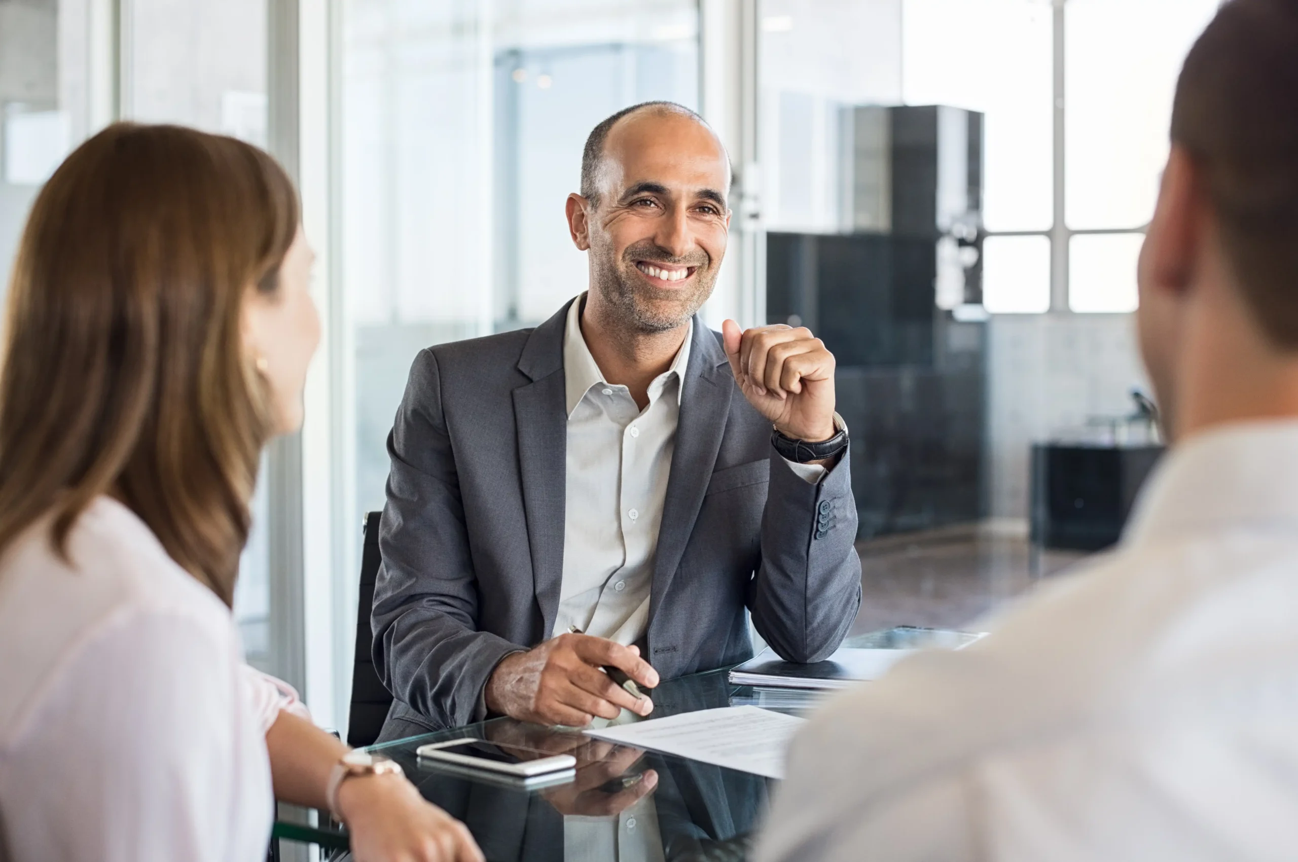 Three professionals at conference table consulting