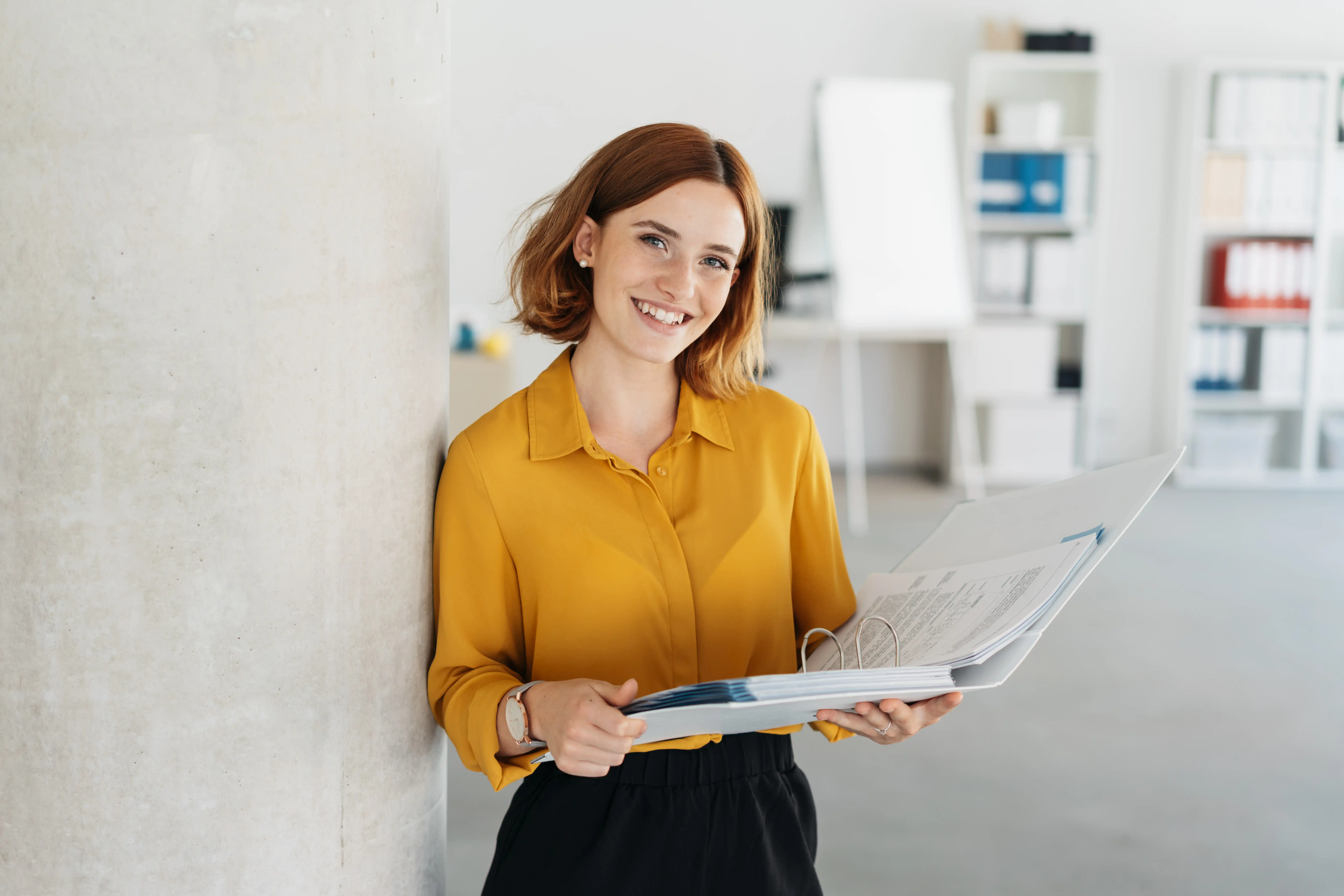 Young professional with yellow shirt red hair at work