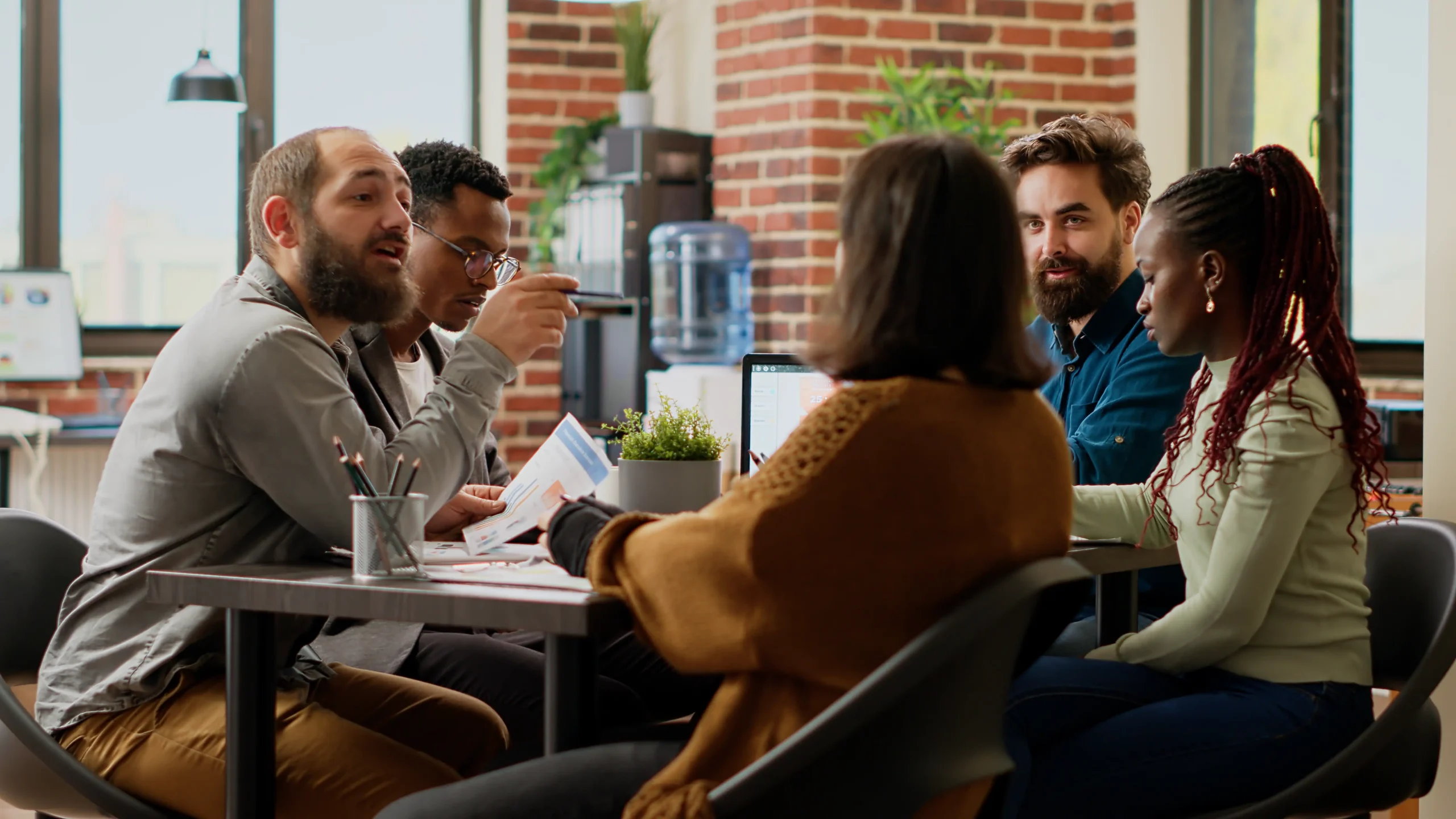 Group of coworkers at a table solving a problem together