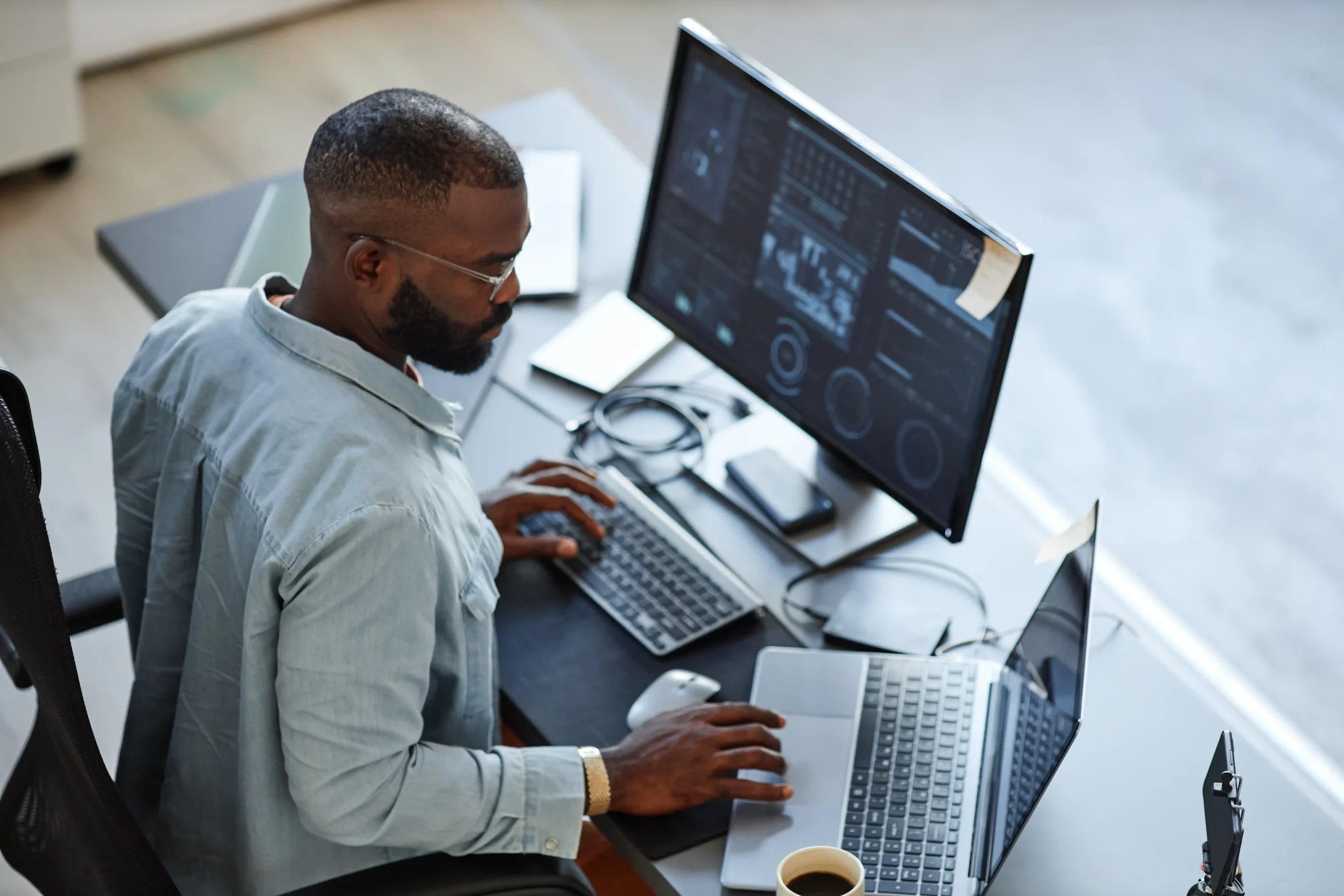 Man at desk with multiple monitors doing security work