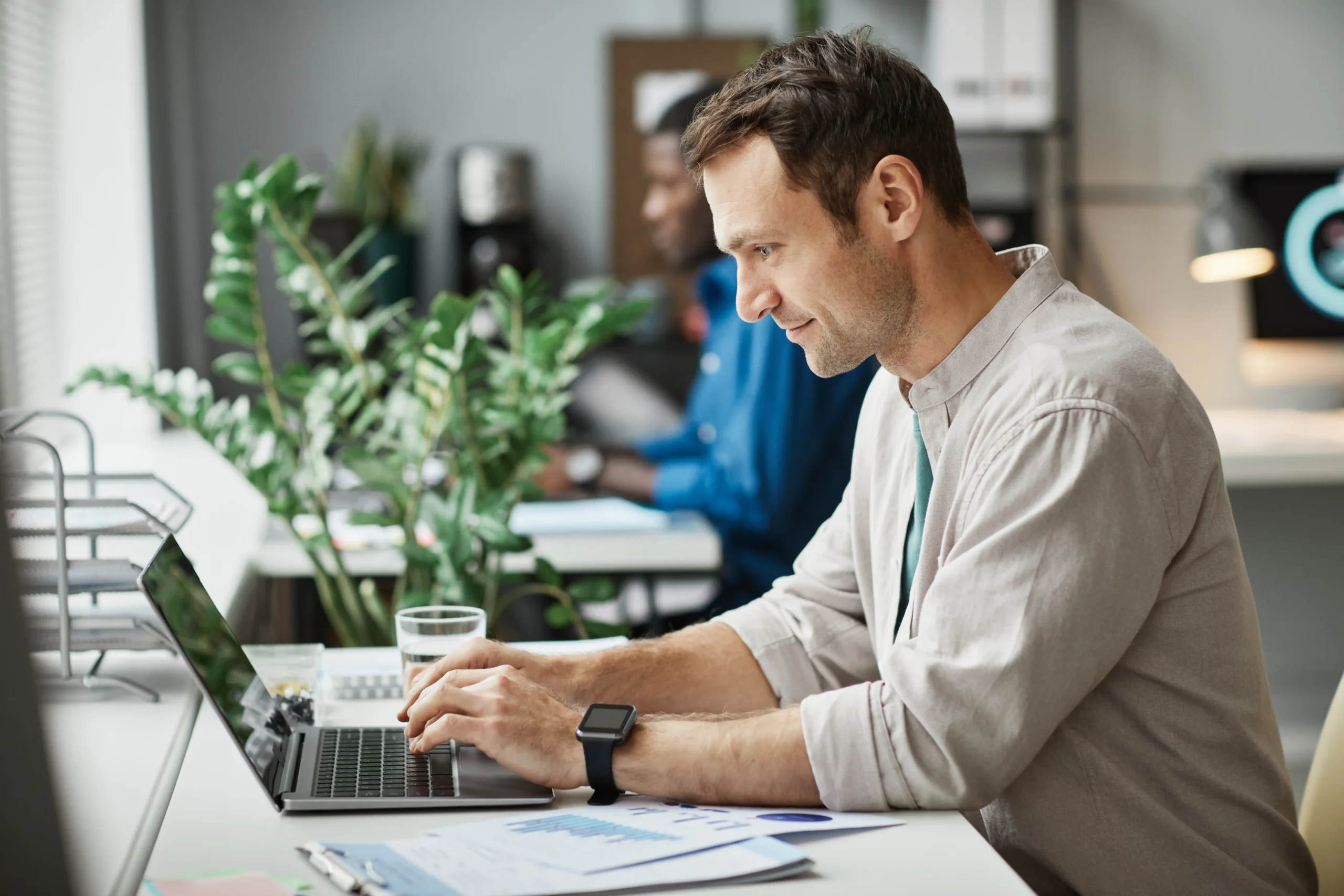 man in beige shirt typing on computer