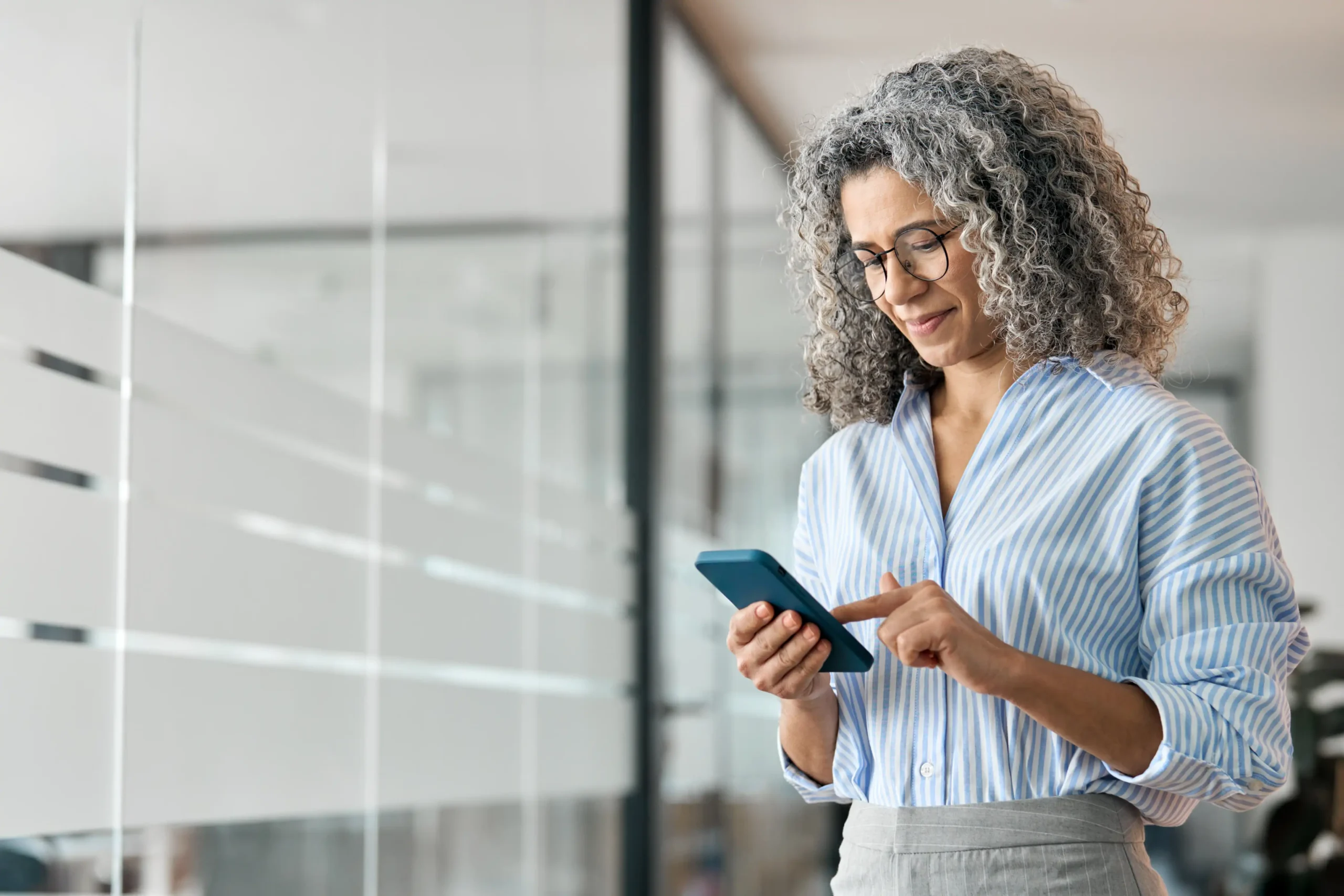 Professional woman at office getting support on her iphone