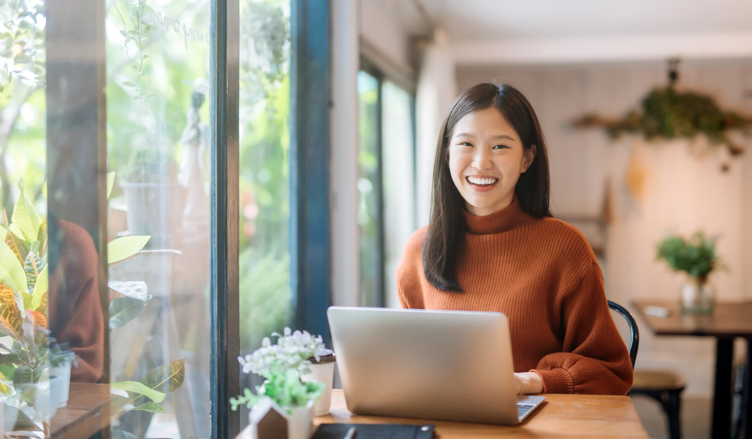 smiling woman at work from home desk at laptop