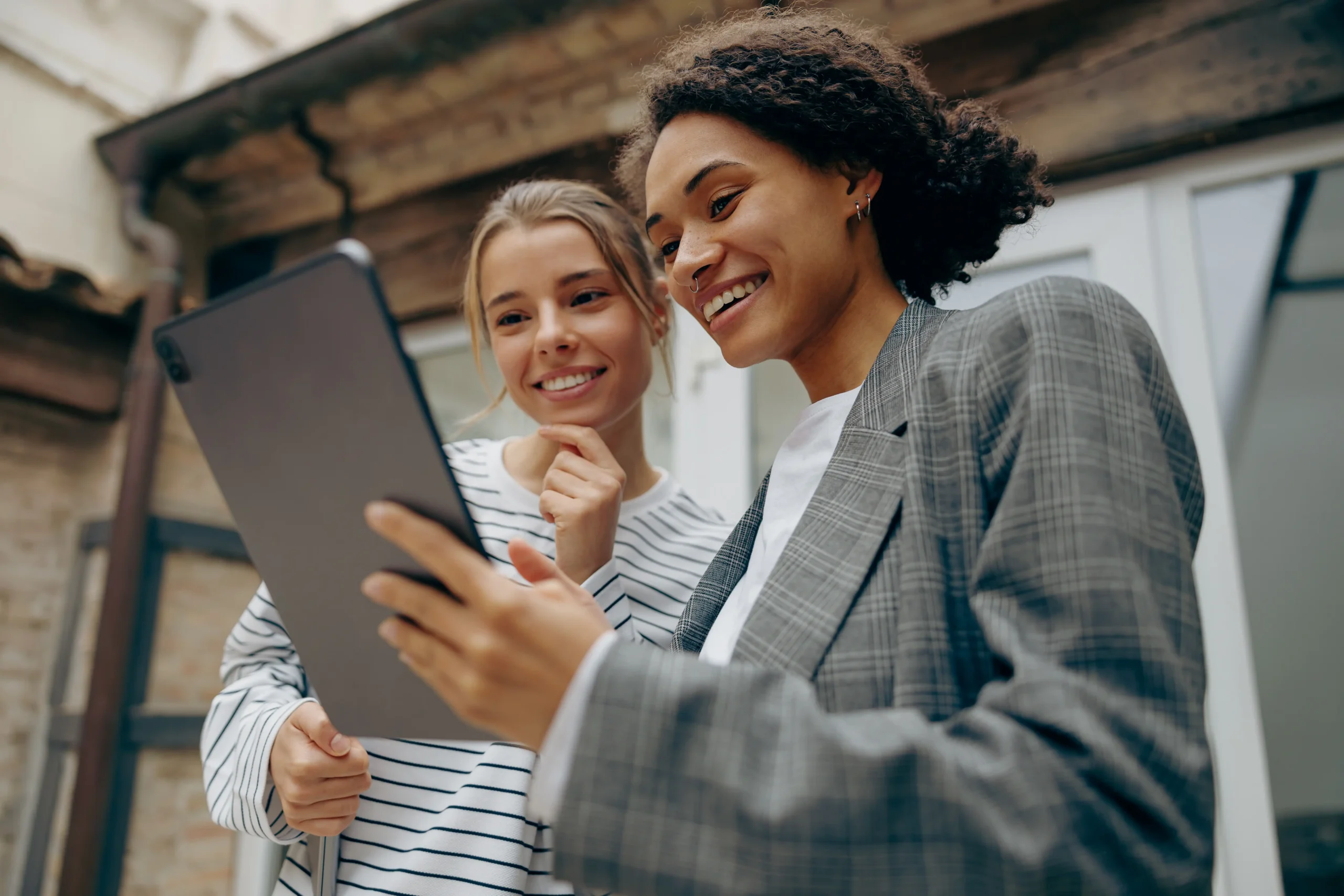 two young colleagues outside looking at ipad