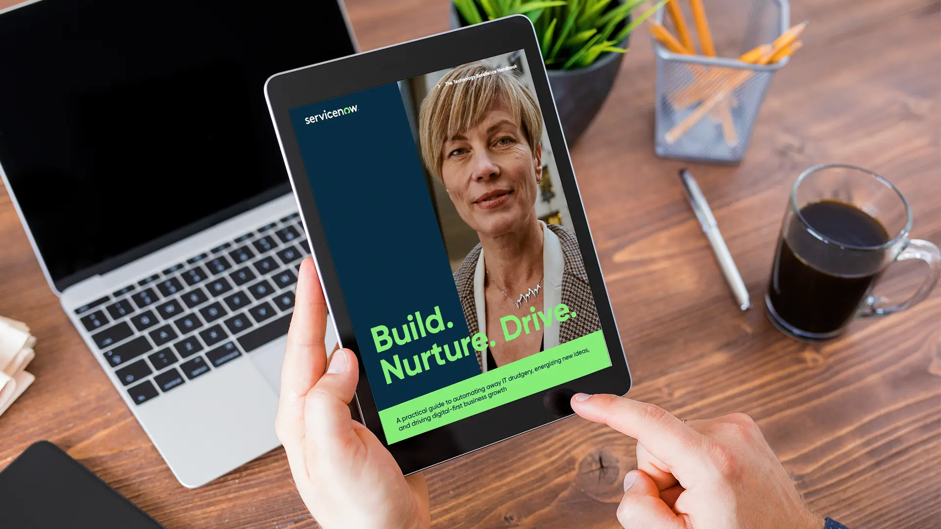 ebook presented on an ipad in front of a desk with a laptop and coffee